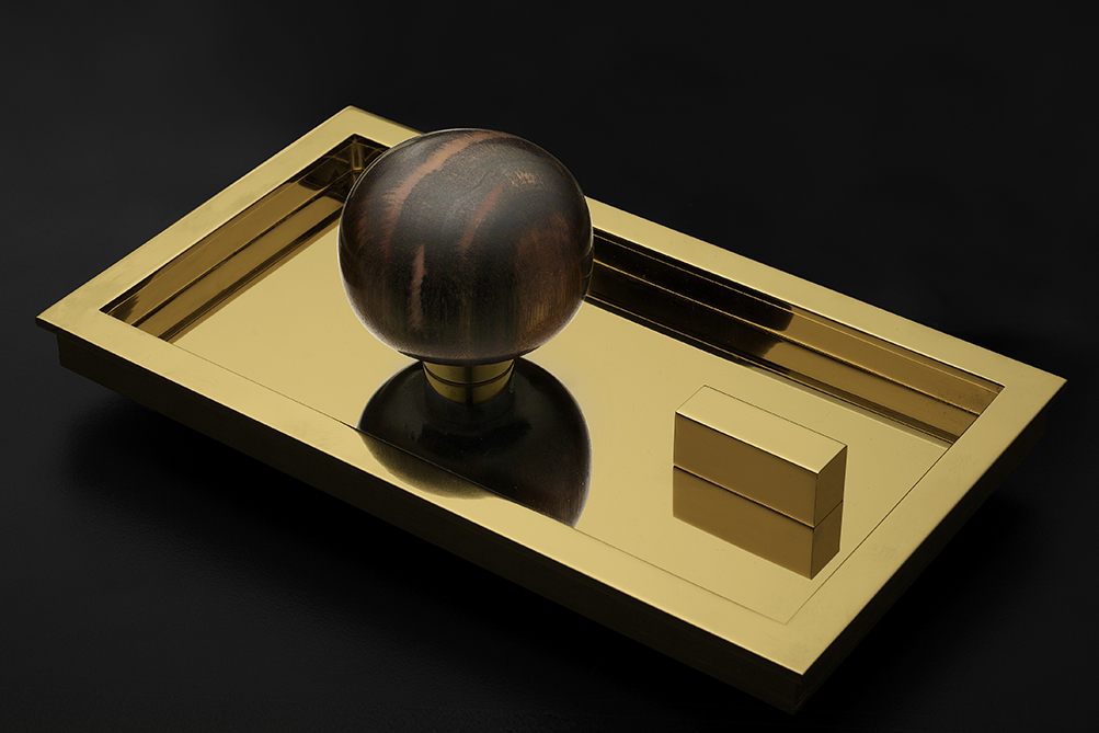 Minimalist wooden door knob on polished brass backplate with a rectilinear thumbturn.