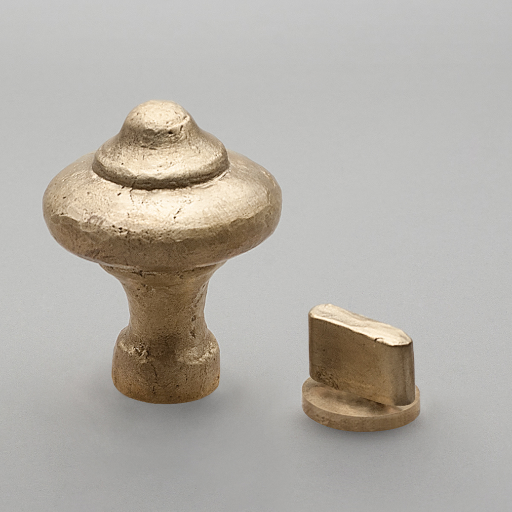 Artisanal cast door knob and thumbturn in distressed brass.
