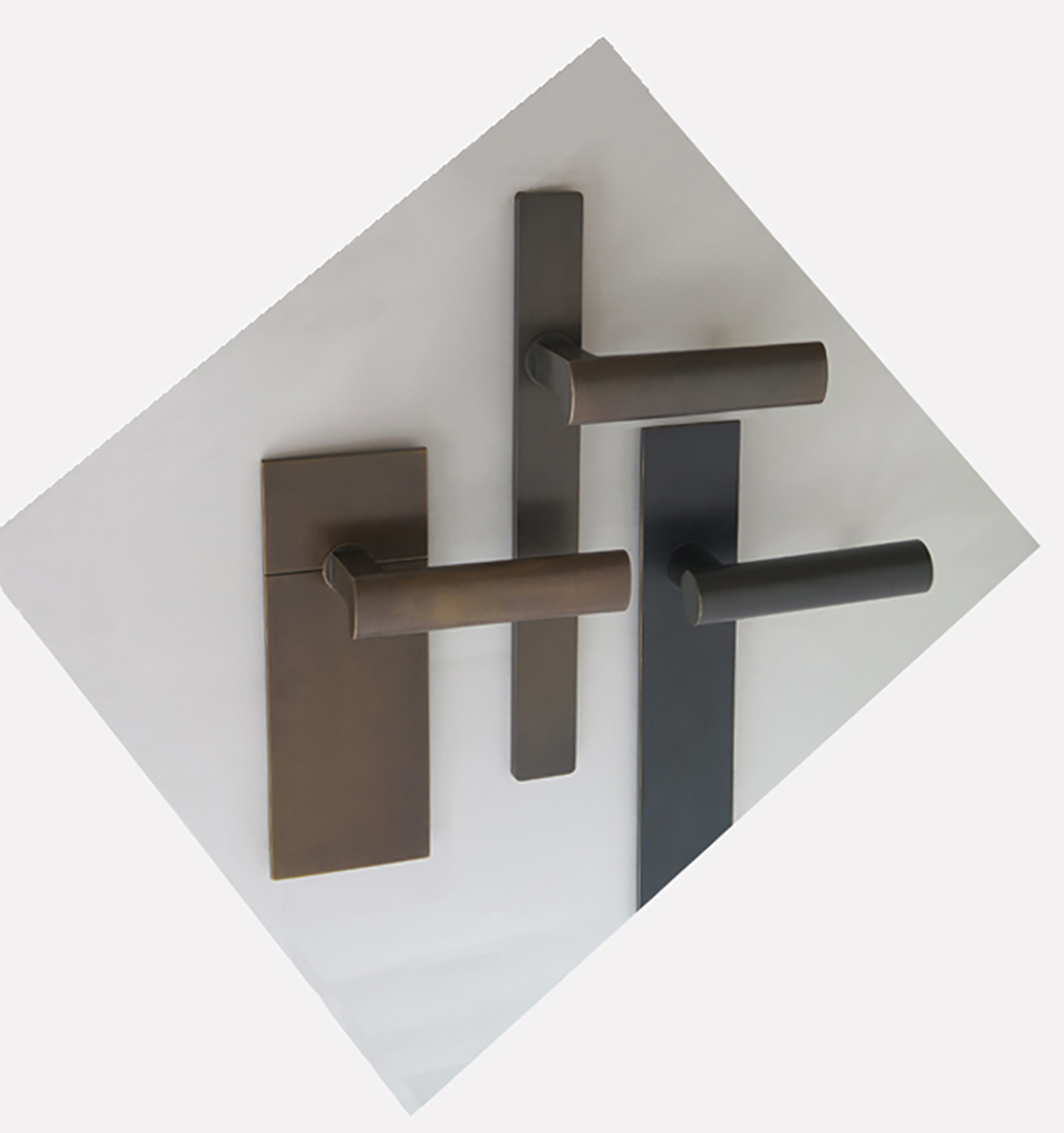 Three modern and minimalist door handles in dark finishes on oversized backplates.